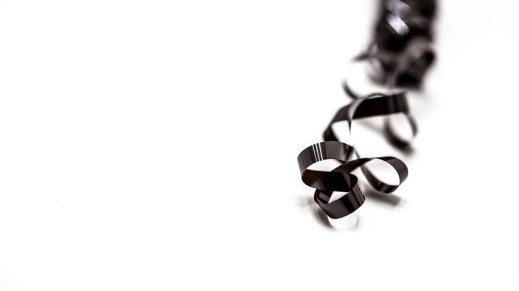 unspooled magnetic tape over a white background