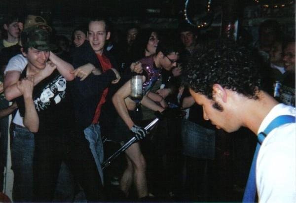 The view of a punk crowd at a small venue in New Jersey in the 1990s, over the shoulder of the author of this post as he plays guitar.