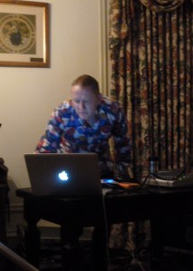 A man leans over an Apple computer, DJ-ing. Marcus Boon Rocks the Spring Workshop After Party--Image by JS