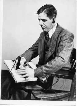 Piechowski, wearing a suit, scans the pen of the A-2 reader over a document.