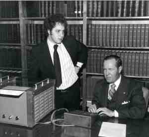 A young Kurzweil stands by his reading machine, demonstrated by Jernigan, who is seated.