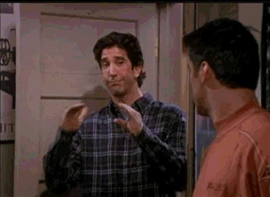 This is a gif where one man is telling another to quiet down through a hand motion
