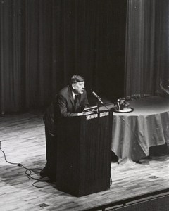 Photograph of Auden speaking at the Boston Sheraton Hotel, with Professor John L. Mahoney sitting on stage, February 23, 1966, Box 60, Folder 9, Francis W. Sweeney, SJ, Humanities Series Director's Records, MS2002-37, John J. Burns Library, Boston College.