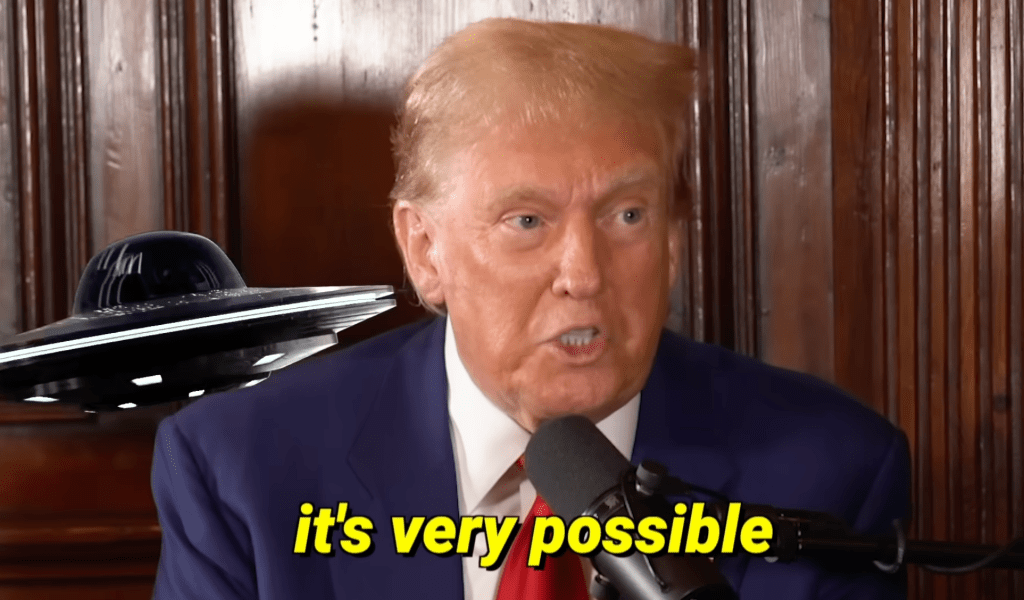 still of an angry white man with overcombed reddish hair and a superimposed UFO on his right shoulder